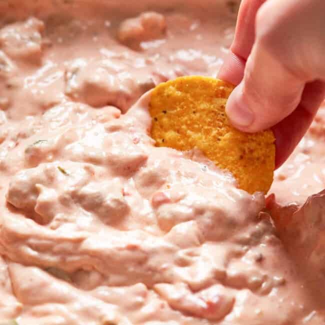 dipping chip into crockpot sausage cream cheese dip