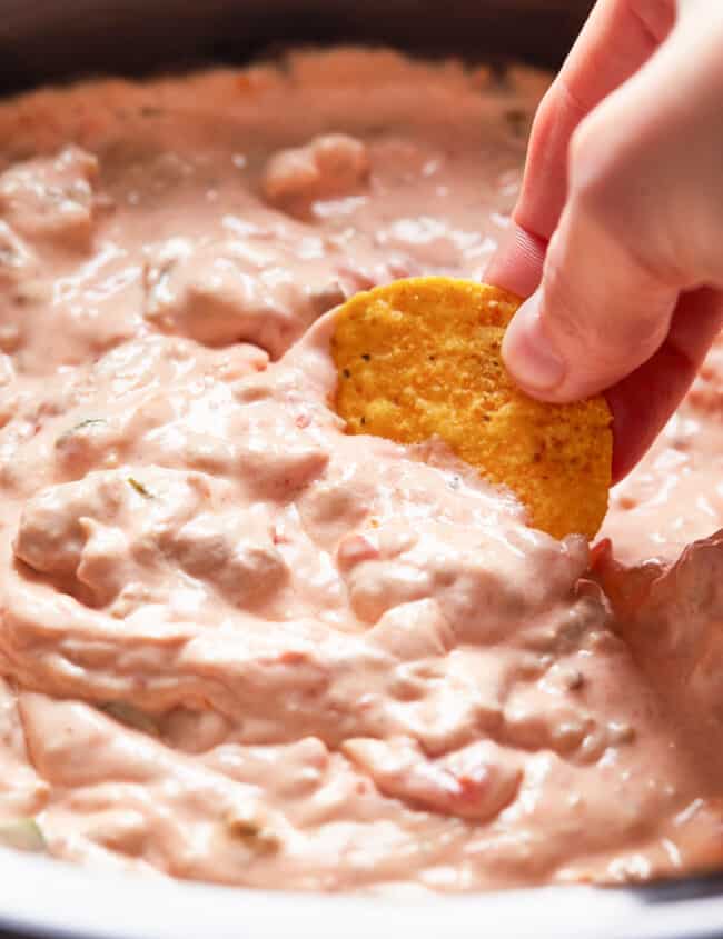 dipping chip into crockpot sausage cream cheese dip
