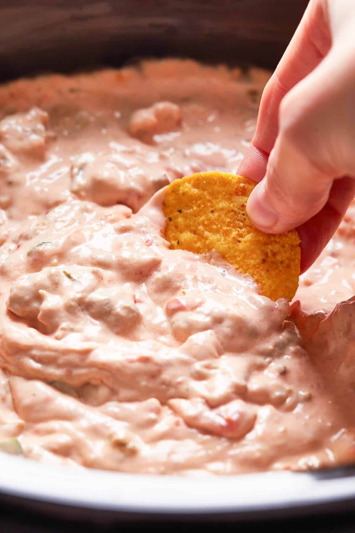 dipping chip into crockpot sausage cream cheese dip