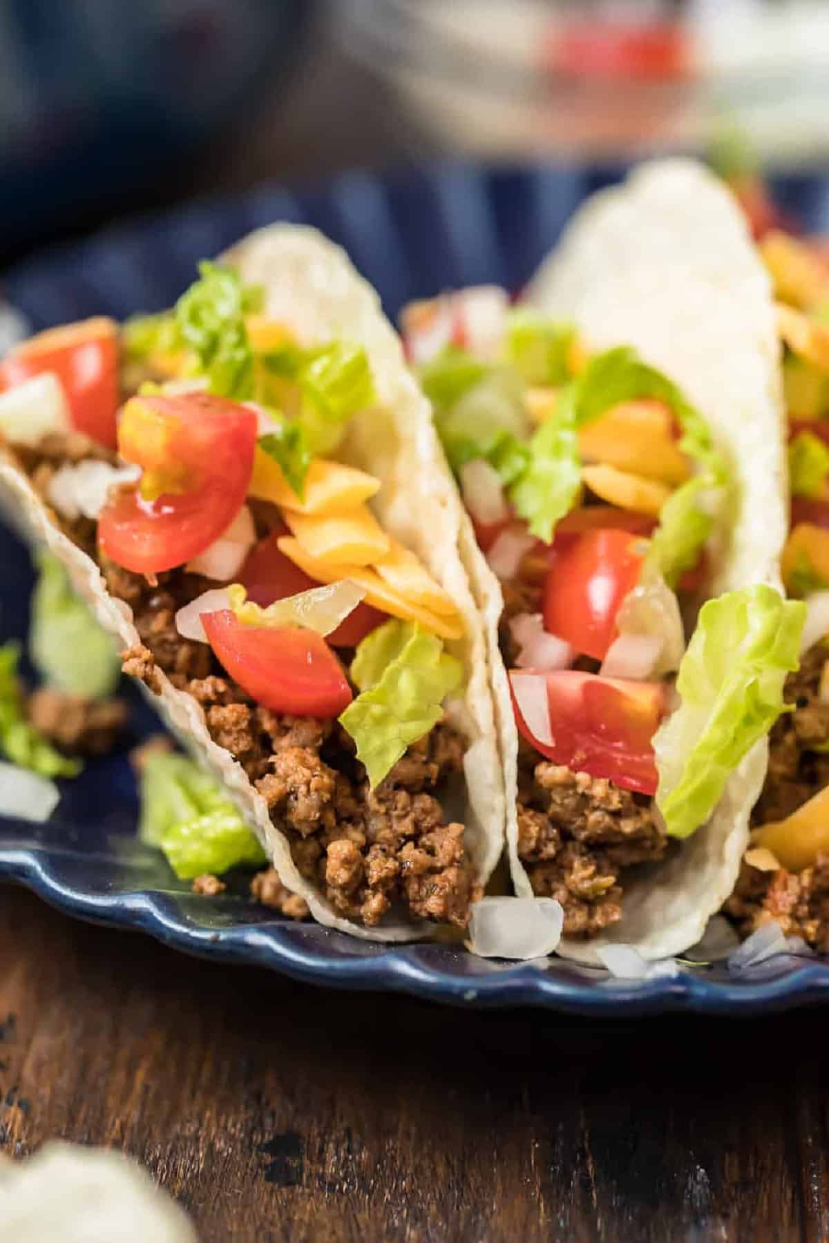 A plate of tacos with crockpot taco meat and vegetables.