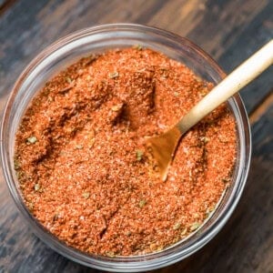 A bowl of blackened seasoning with a wooden spoon.
