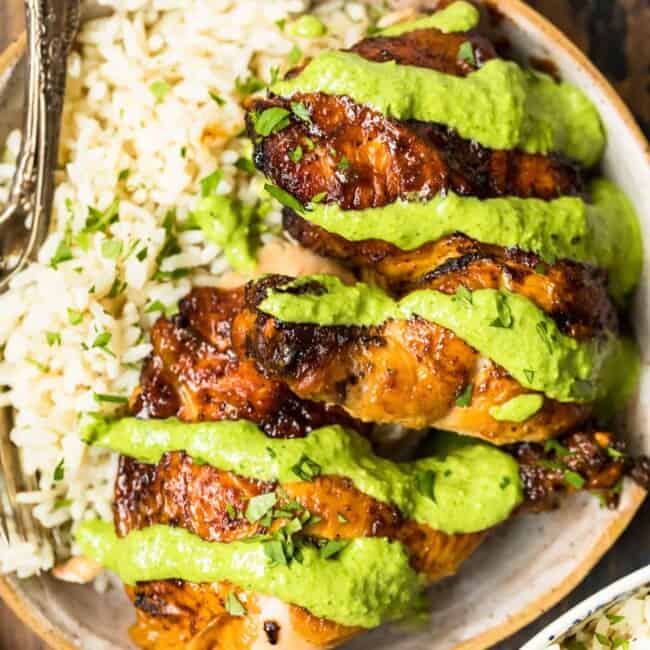 peruvian chicken with green sauce on plate with rice