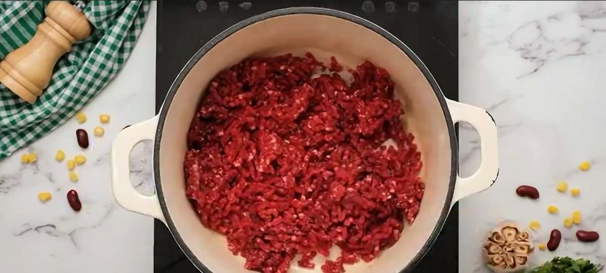 Cooking ground beef in a Dutch oven.
