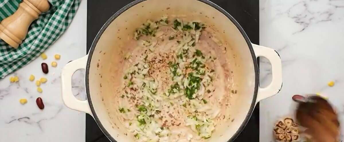 Cooking onion and jalapeno in a Dutch oven.