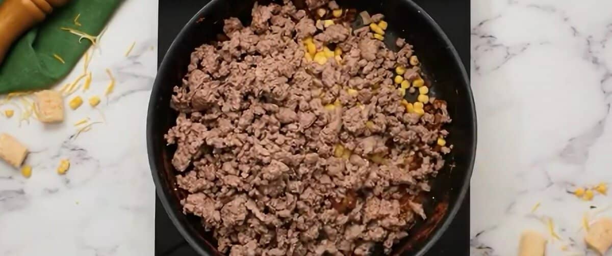 Add beef and corn to the pot with onions and seasonings.