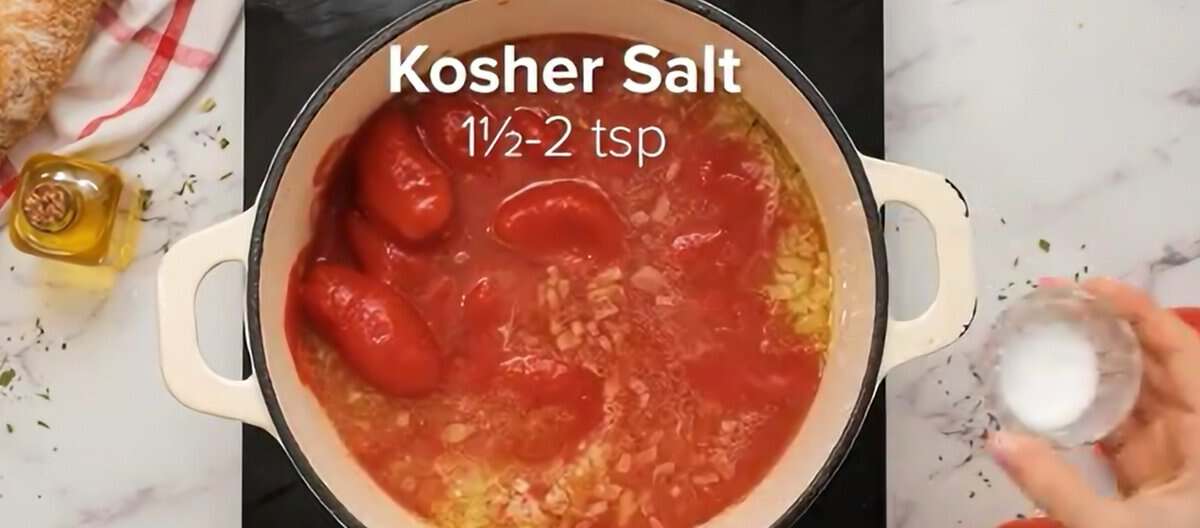 Adding canned tomatoes, broth, and seasoning to the Dutch oven.