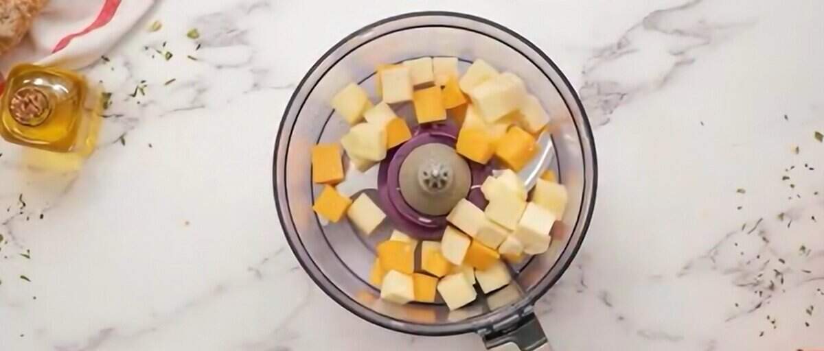 Chunks of cheese in a food processor.