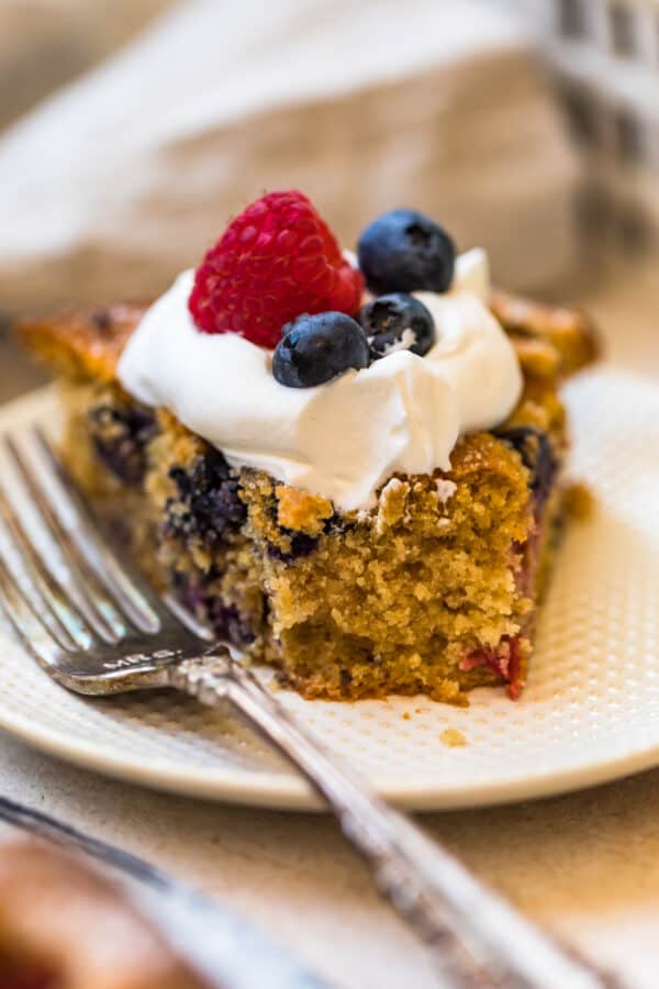 A slice of Blueberry Raspberry Coffee Cake with a forkful cut off of the end