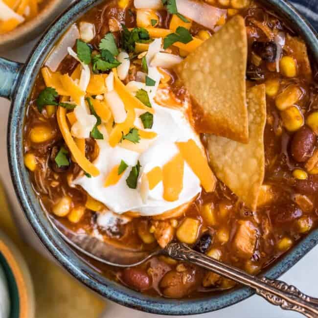 chicken taco soup in a bowl with chips and sour cream garnish