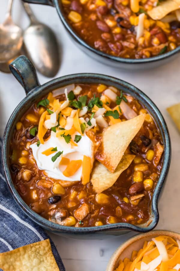 Chicken taco soup in a bowl topped with sour cream and chips
