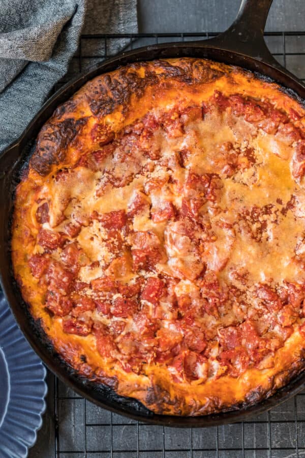 A baked chicago deep dish pizza in a skillet