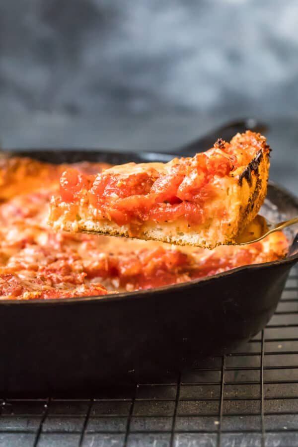 A slice of pizza being lifted out of the skillet