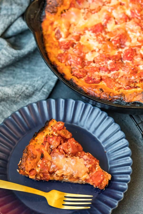 A slice of chicago deep dish pizza on a blue plate 