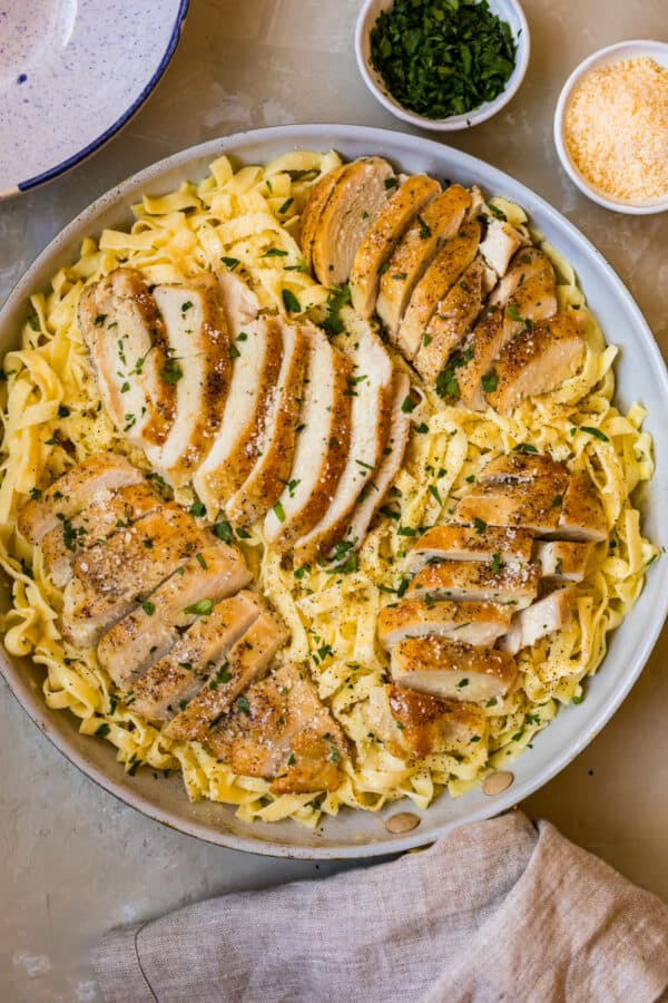 Sliced chicken breast on top of the pasta