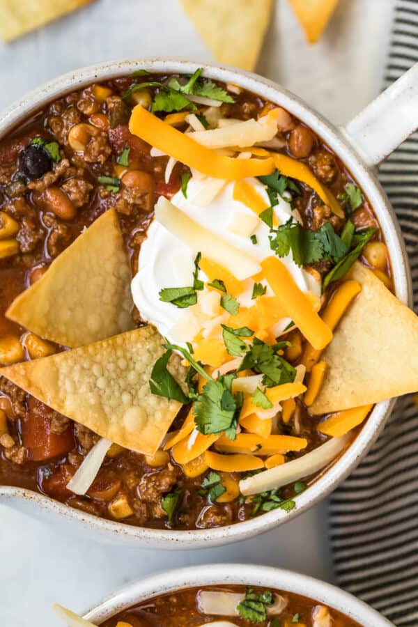 taco soup topped with sour cream and tortillas