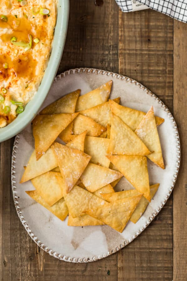 Wonton chips on a plate served next to a dip