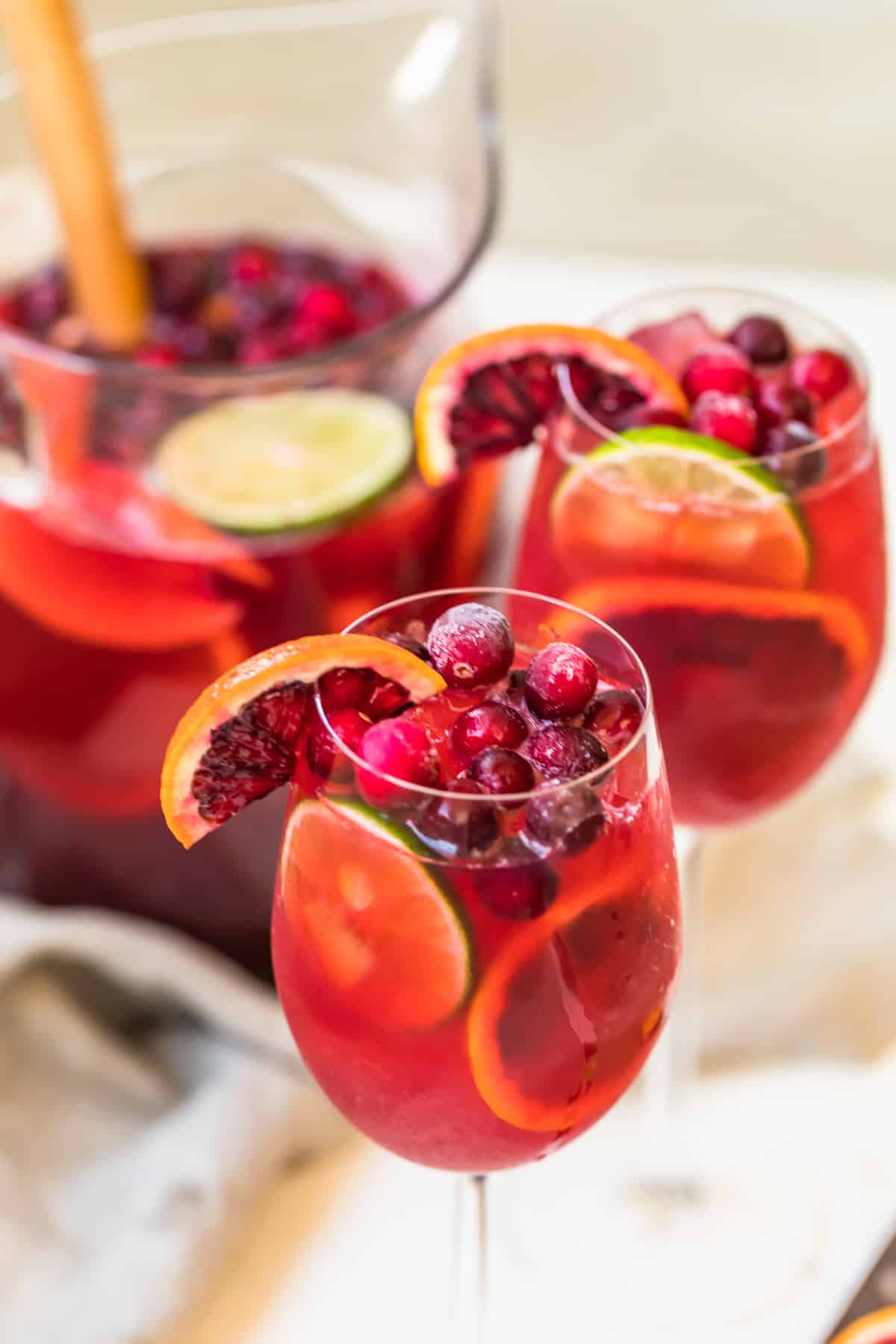 Two glasses of non-alcoholic cranberry sangria with orange slices.