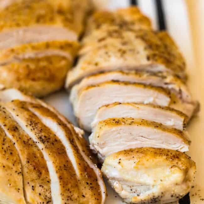 sliced pan seared chicken breasts on a cutting board