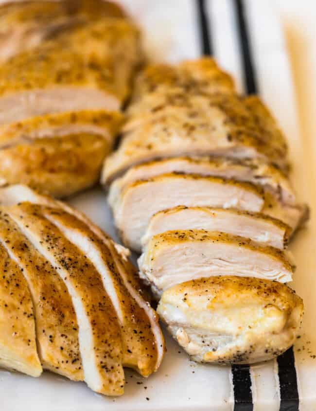 sliced pan seared chicken breasts on a cutting board