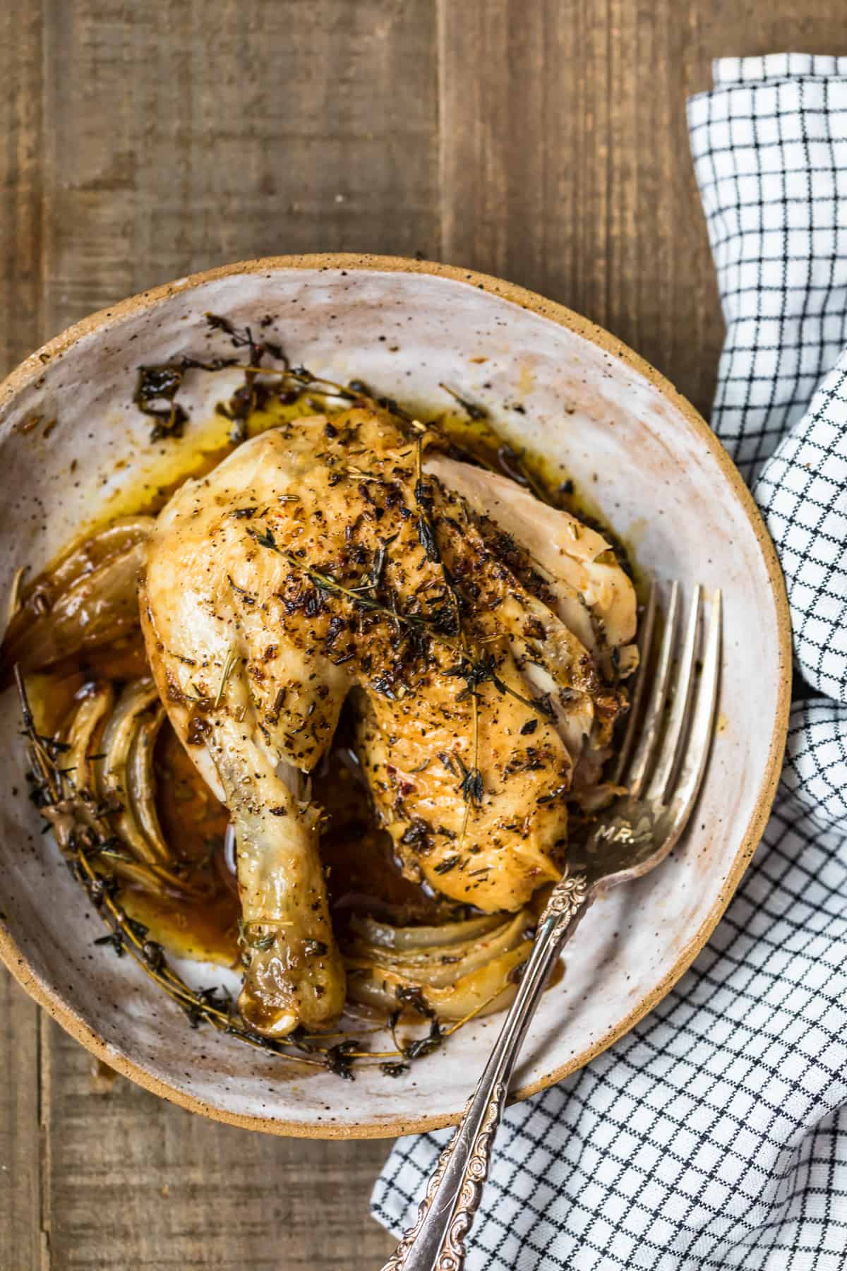 Roasted chicken thigh in a bowl served with the juices