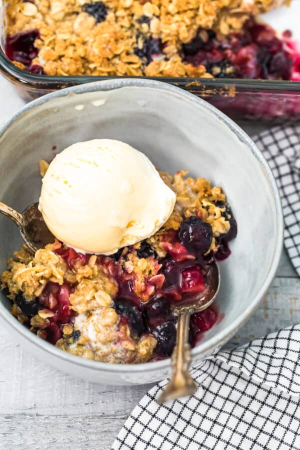 bowl of berry crisp topped with ice cream