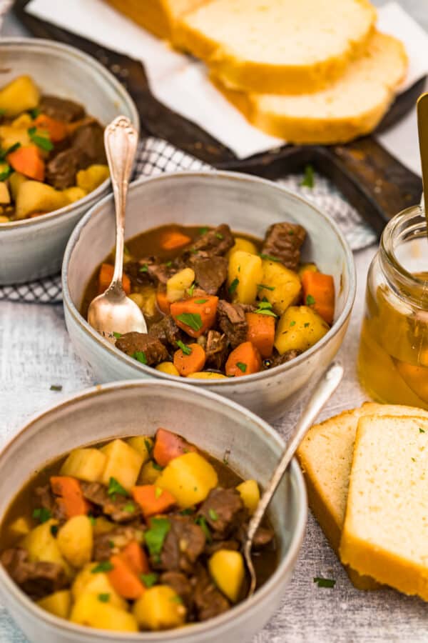 beef stew in bowls next to bread