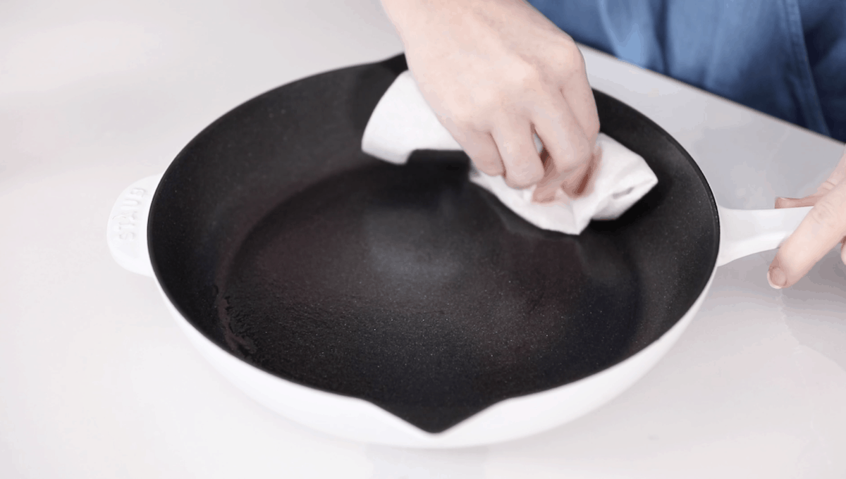 wiping oil on skillet to season