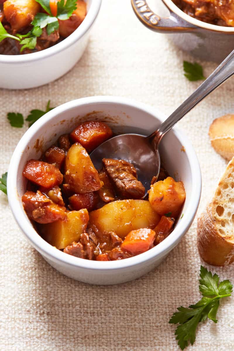 spoon in white bowl of red wine beef stew