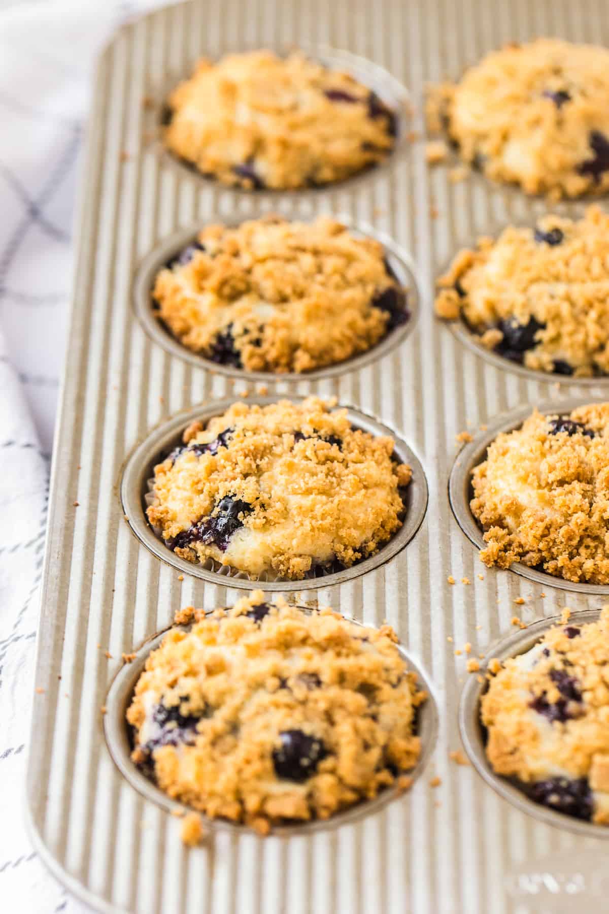 side shot of muffin tin with blueberry muffins