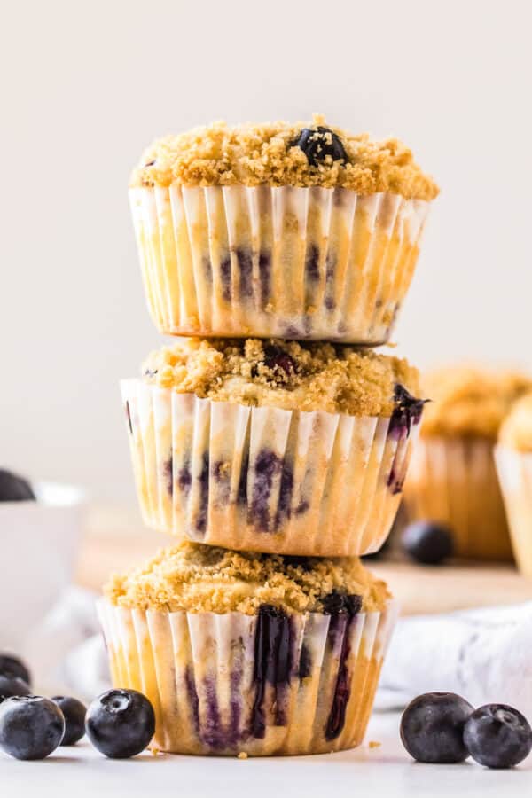 three muffins stacked with blueberries