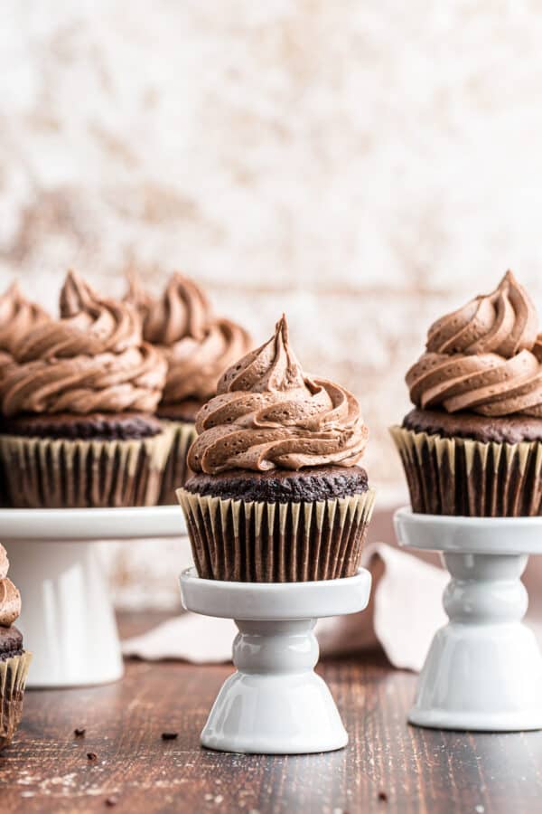 chocolate cupcakes topped with chocolate icing on stands