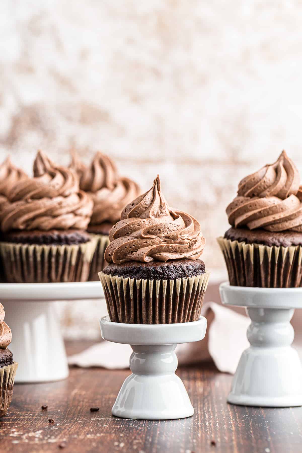 chocolate cupcakes topped with chocolate icing on stands