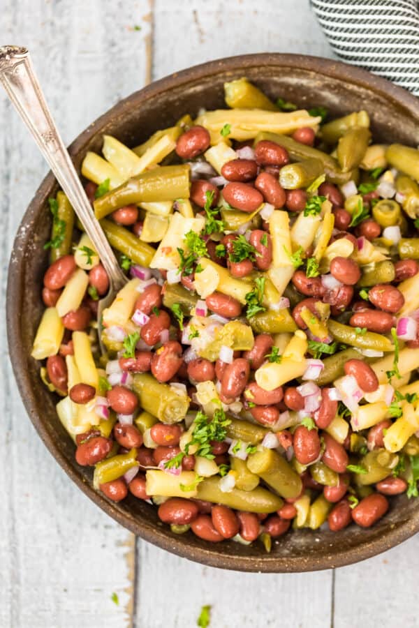 overhead image of three bean salad in bowl with spoon