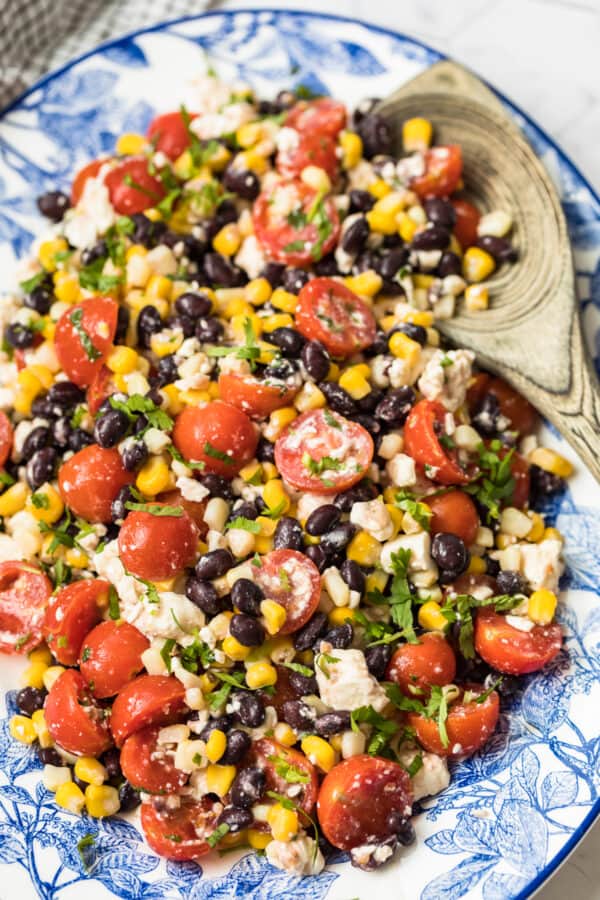 corn salad with tomatoes on blue platter