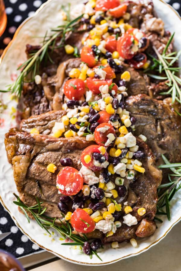 grilled ribeye steaks topped with confetti corn salad