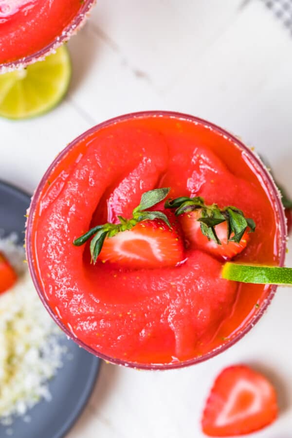 frozen strawberry margaritas garnished with fruit and salt