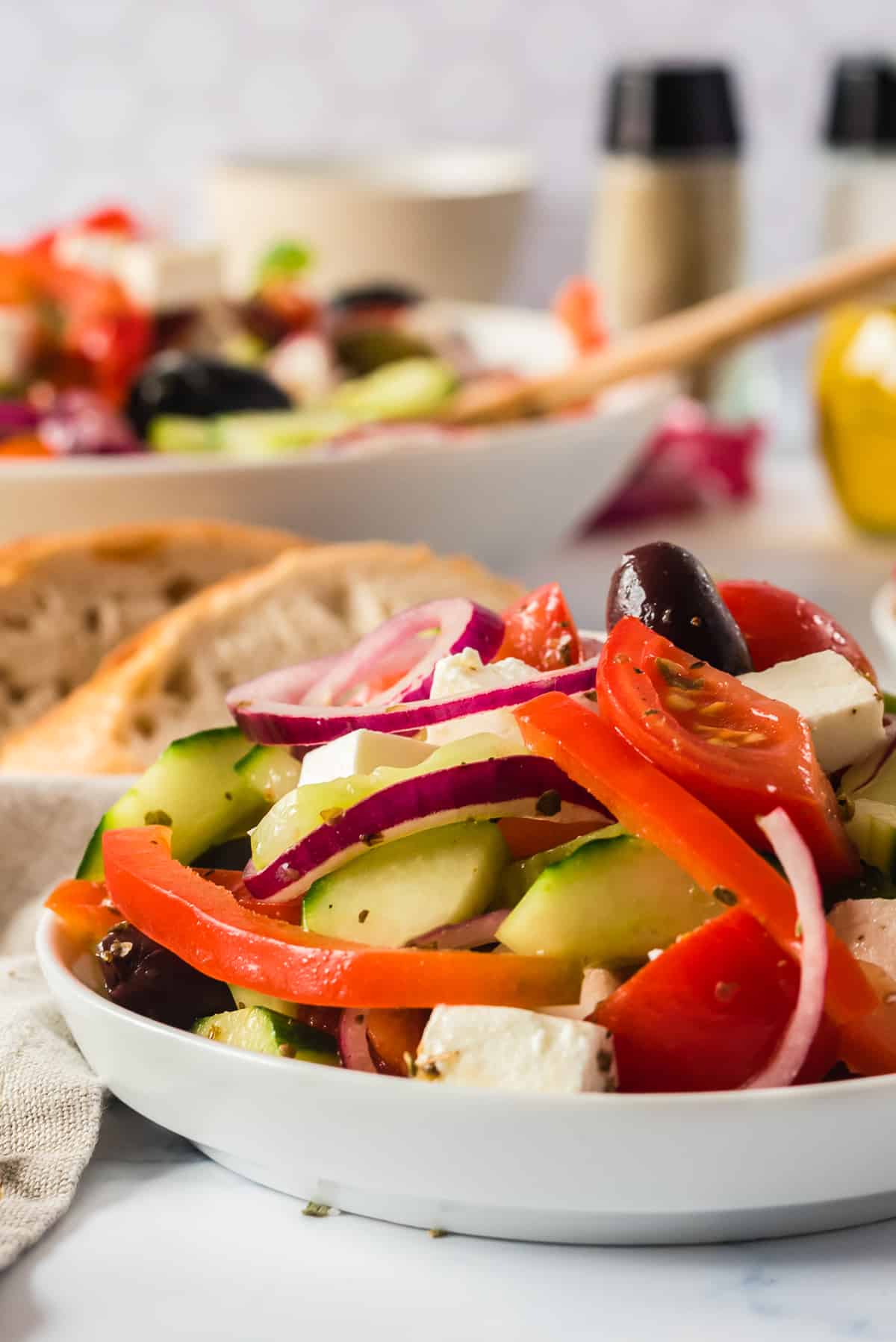 side shote of salad in white bowl with bread