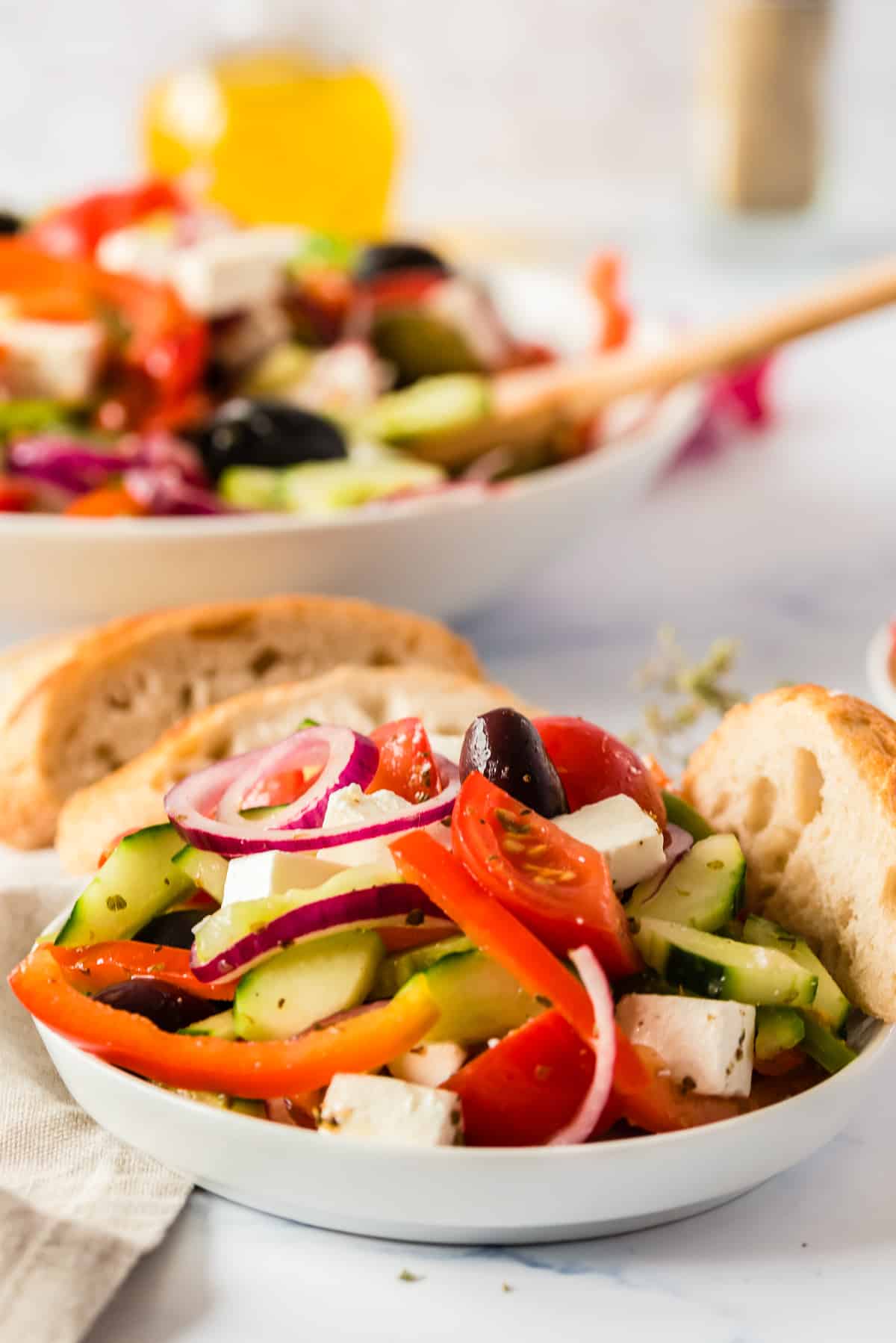side shote of salad in white bowl with bread