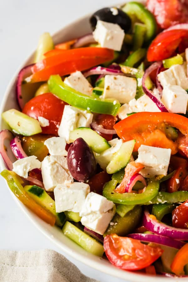 tossed greek salad in white bowl