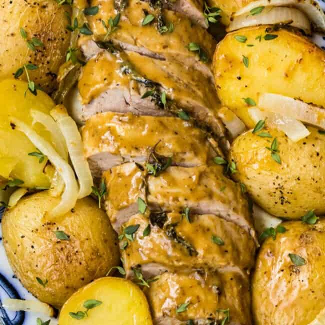 up close image of honey mustard pork tenderloin with potatoes on platter