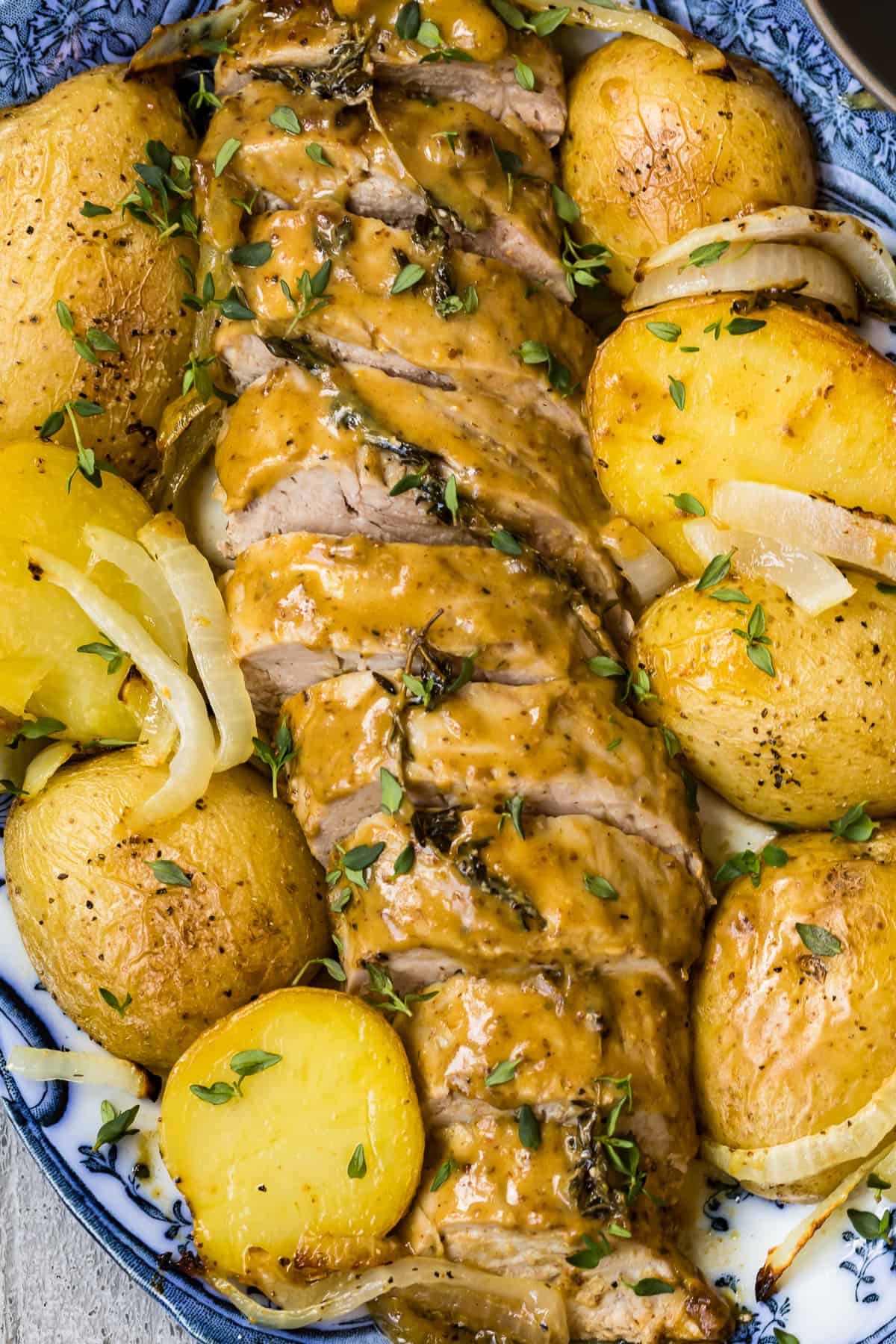 up close image of honey mustard pork tenderloin with potatoes on platter