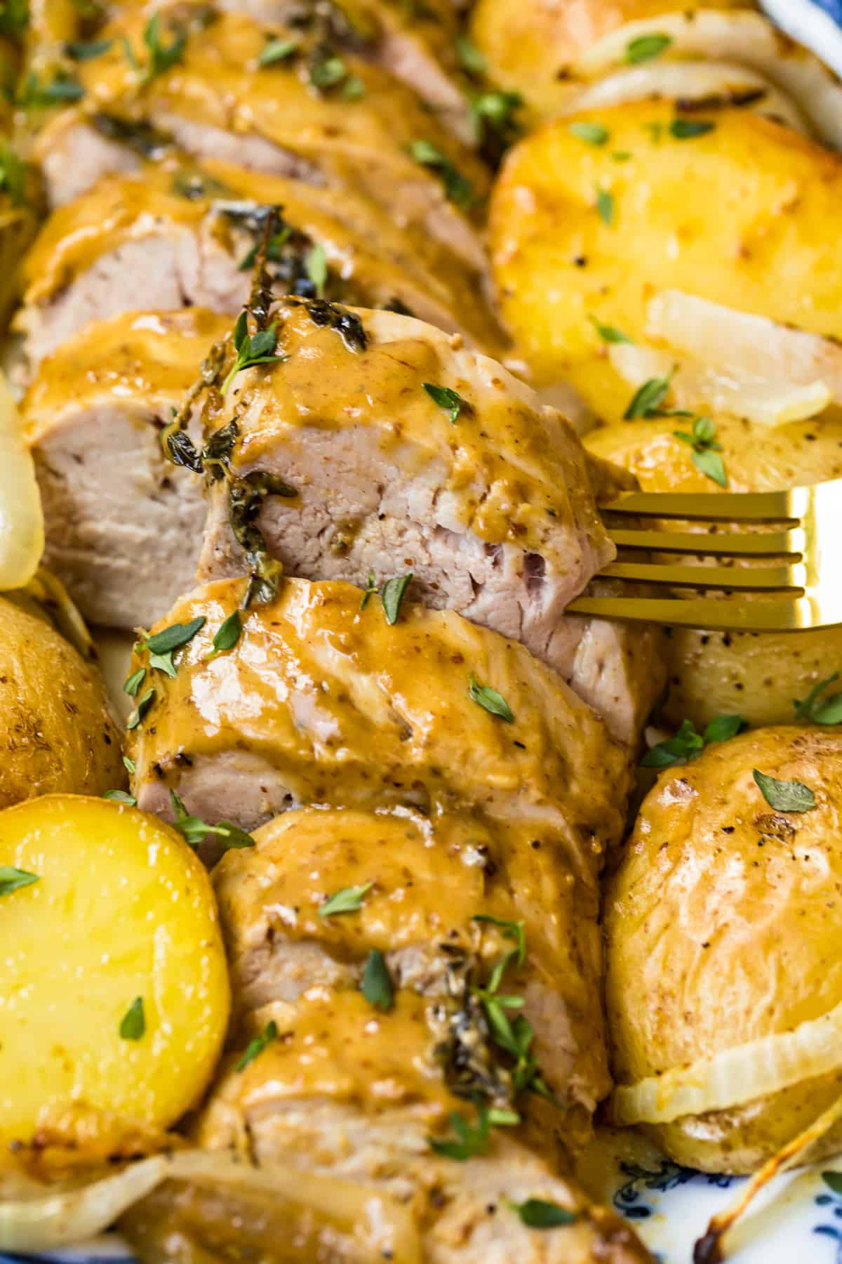 up close image of pork tenderloin with honey mustard sauce and potatoes