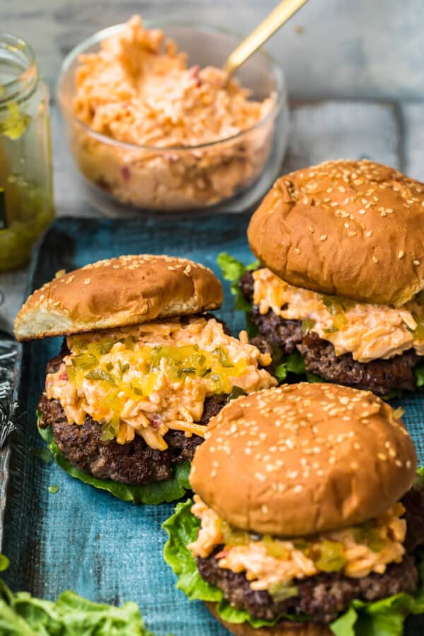 pimento cheeseburgers on blue platter next to relish and pimento cheese