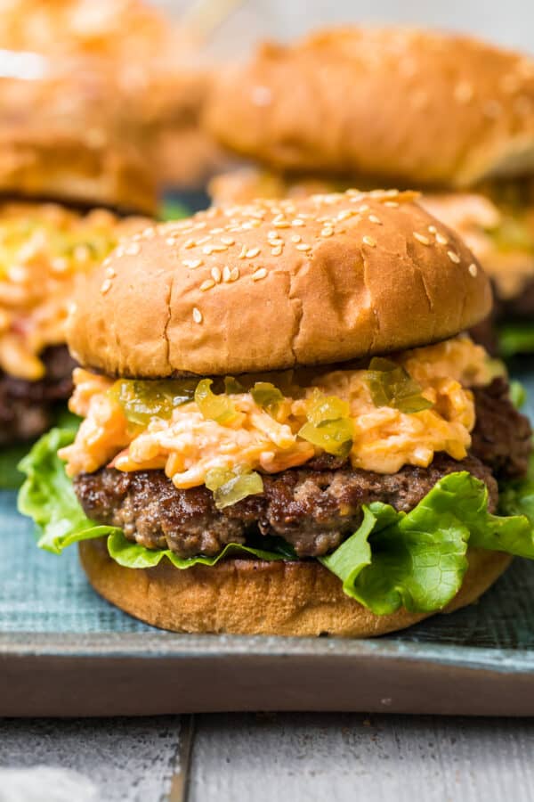 up close image of burger topped with pimento cheese and relish