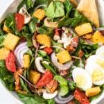 spinach bacon salad with spinach salad dressing in white bowl