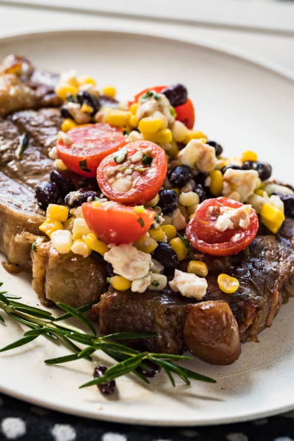 grilled ribeye topped with tomatoes and corn