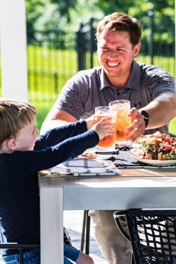 father and son cheersing with iced tea