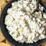 up close image of herbed cottage cheese in bowl surrounded by crackers
