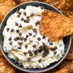 wonton chip dipping in cannoli dip with chocolate chips