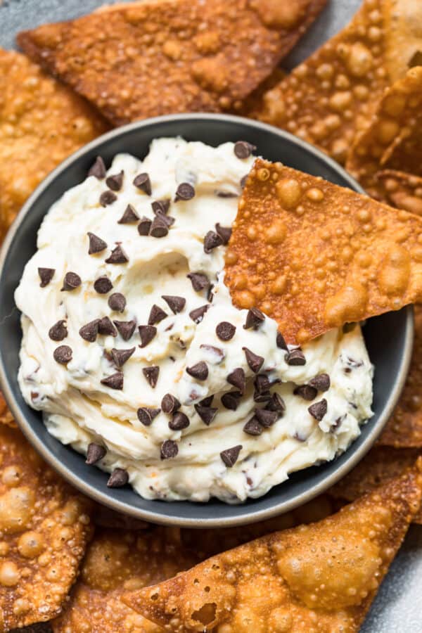 wonton chip dipping in cannoli dip with chocolate chips